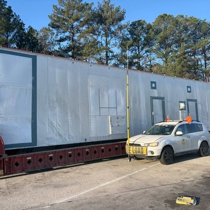 LoadGuard pilot car with high pole escorting an oversize modular load