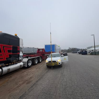 LoadGuard pilot car staged beside a heavy-haul trailer and oversize load