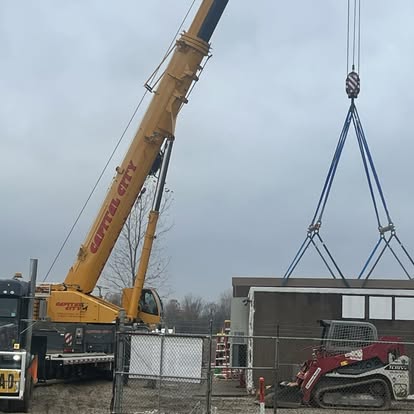 Crane setting a heavy component while a LoadGuard oversize load vehicle is on site